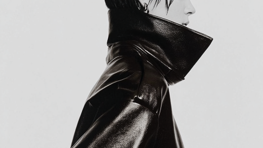 Black leather coat worn by a person on a light gray background